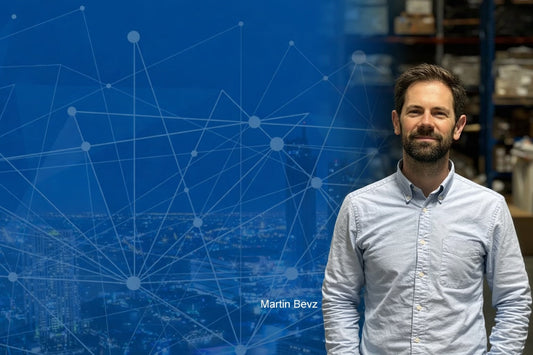 Martin Bevz from Afterglow Controls standing in a warehouse with a blue network graphic background